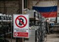 Mineros de bitcoin con el símbolo de prohibido y de fondo la bandera de Rusia
