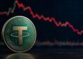 Moneda Tether (USDT) física verde y dorada frente a gráfico de precios bajista.