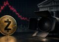 Moneda física de Zcash al lado de un foco de estudio, con un gráfico de precios bajista en rojo.