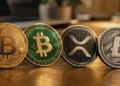 Sobre una mesa, monedas de BTC, BCH, XRP y LTC.