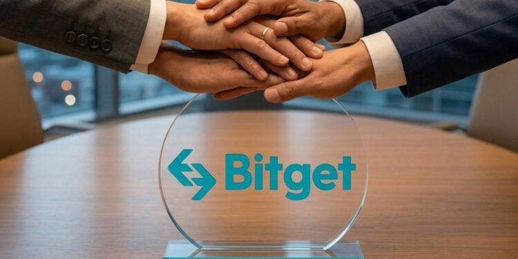 Personas en traje estrechando y uniendo sus manos sobre una placa transparente con el logo de Bitget en una mesa de reuniones.