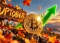 Una moneda de bitcoin delante delante de un cartel que dice "uptober" y junto a una flecha verde.
