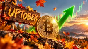 Una moneda de bitcoin delante delante de un cartel que dice "uptober" y junto a una flecha verde.