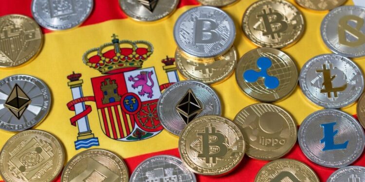 Muchas criptomonedas y detrás la bandera de España.