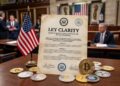 Documento legislativo que dice "Ley Clarity", con criptomonedas alrededor, y la bandera de EE. UU.