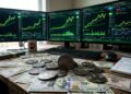 Monedas de XMR con dólares alrededor y gráficas de mercado en verde en el fondo.