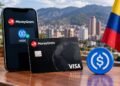 Tarjeta Visa MoneyGram y aplicación móvil USDC con bandera de Colombia.