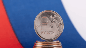 Una moneda de rublo de Rusia y detrás la bandera de Rusia