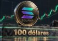 Una moneda física de solana sobre un bloque de pieda que dice 100 dólares.