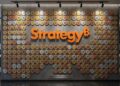 Pared con el logo de Strategy y monedas de bitcoin.
