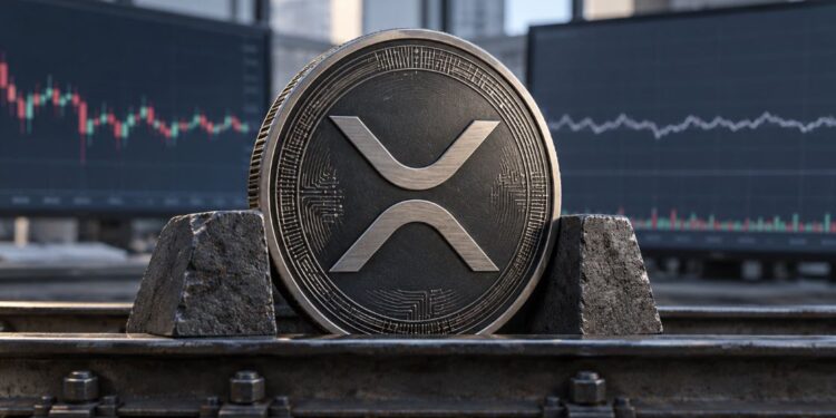 Una moneda física de XRP agarrada por dos bloques de pierdra sobre un escritorio.
