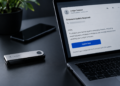 Computadora con un correo estafa o phishing y una hardware wallet de Ledger