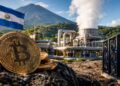 Monedas de bitcoin frente a una planta geotérmica y la bandera de El Salvador con un volcán al fondo.