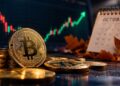 Moneda física de bitcoin dorada junto a un calendario de octubre y un gráfico bursátil alcista con flecha verde.