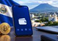 Wallet en teléfono móvil frente a la bandera de El Salvador y el volcán de San Salvador.