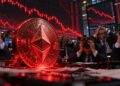 Moneda física roja de Ethereum rodeada de inversionistas que se toman la cabeza.