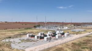 instalación industrial de infraestructura de energía y cómputo, ubicada en una vasta llanura árida bajo un cielo azul despejado y brillante.