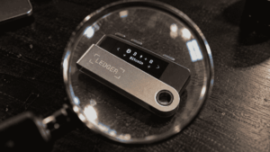Un dispositivo de Ledger visto a través de una lupa.