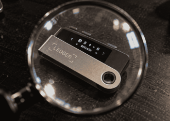 Un dispositivo de Ledger visto a través de una lupa.
