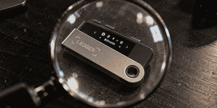 Un dispositivo de Ledger visto a través de una lupa.