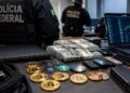 Agentes de la Policía Federal de Brasil junto a fajos de dólares, criptomonedas y computadoras incautadas.