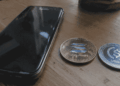 Un teléfono Samsung, una moneda de Solana y una moneda de USDC sobre una mesa.