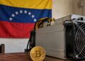 Un equipo de minería y una moneda física de bitcoin sobre una mesa.